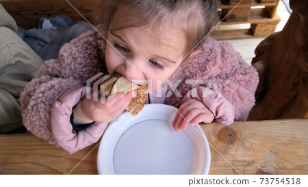 Girl eat delicious fresh crepes in comfortable cafe Girl eat delicious fresh crepes in comfortable cafe 73754518