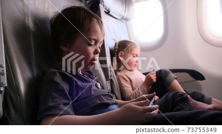 Masked children on a plane with gadgets Masked children on a plane with gadgets 73755349