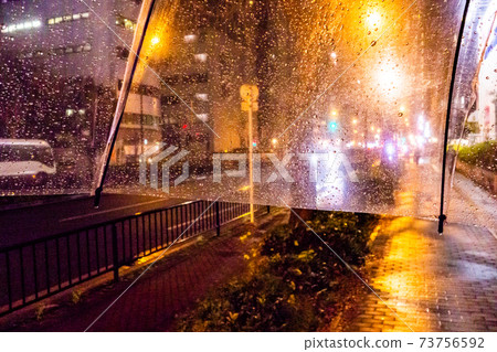 通過乙烯基傘看到的雨夜景 73756592