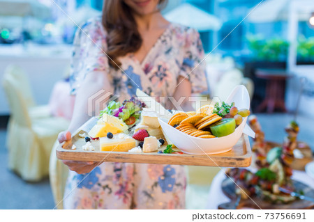 Woman is holding healthy breakfast of cheese, biscuits and fresh fruit. 73756691