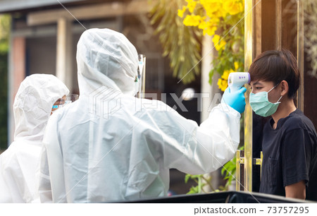 Proactive home health nurse takes the Temperature Measurement check scanner to monitor in hand at local Thaiand 73757295