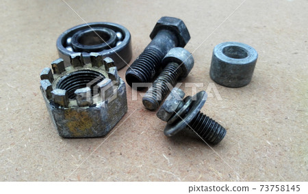 Used bearings, gaskets, screws and some other mechanical components of engines isolated on the high-pressure timber board. Used bearings, gaskets, screws and some other mechanical components of engines isolated on the high-pressure timber board. 73758145