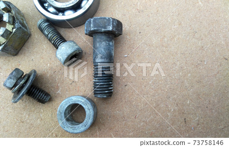 Used bearings, gaskets, screws and some other mechanical components of engines isolated on the high-pressure timber board. Used bearings, gaskets, screws and some other mechanical components of engines isolated on the high-pressure timber board. 73758146
