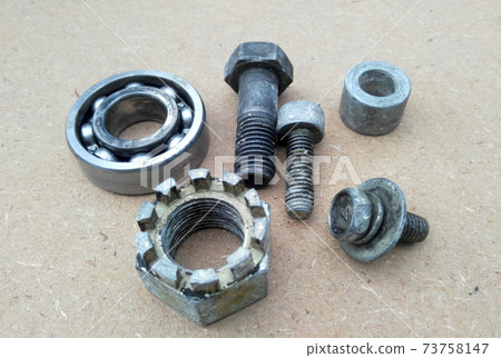 Used bearings, gaskets, screws and some other mechanical components of engines isolated on the high-pressure timber board. Used bearings, gaskets, screws and some other mechanical components of engines isolated on the high-pressure timber board. 73758147