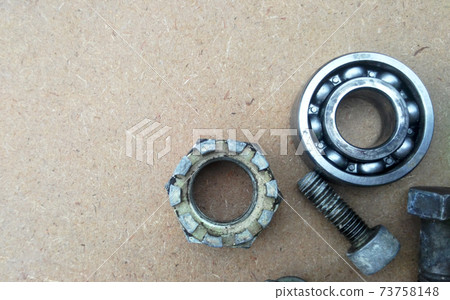 Used bearings, gaskets, screws and some other mechanical components of engines isolated on the high-pressure timber board. Used bearings, gaskets, screws and some other mechanical components of engines isolated on the high-pressure timber board. 73758148