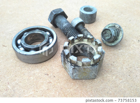 Used bearings, gaskets, screws and some other mechanical components of engines isolated on the high-pressure timber board. Used bearings, gaskets, screws and some other mechanical components of engines isolated on the high-pressure timber board. 73758153