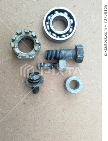 Used bearings, gaskets, screws and some other mechanical components of engines isolated on the high-pressure timber board. Used bearings, gaskets, screws and some other mechanical components of engines isolated on the high-pressure timber board. 73758158
