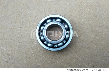 Used bearings, gaskets, screws and some other mechanical components of engines isolated on the high-pressure timber board. Used bearings, gaskets, screws and some other mechanical components of engines isolated on the high-pressure timber board. 73758162