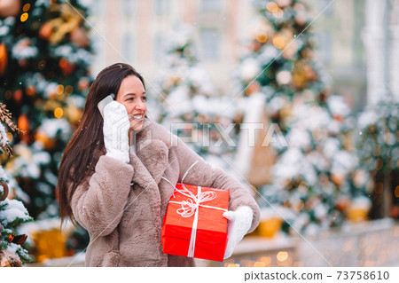 Happy girl near fir-tree branch in snow for new year. Happy girl near fir-tree branch in snow for new year. 73758610