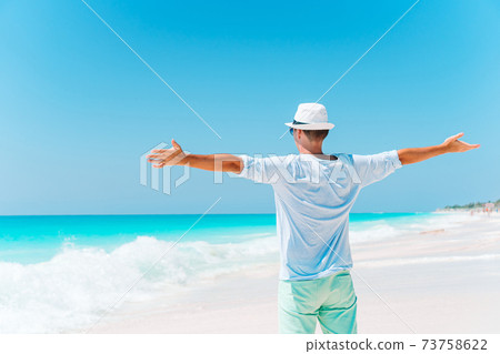 Young man on the white beach on vacation Young man on the white beach on vacation 73758622