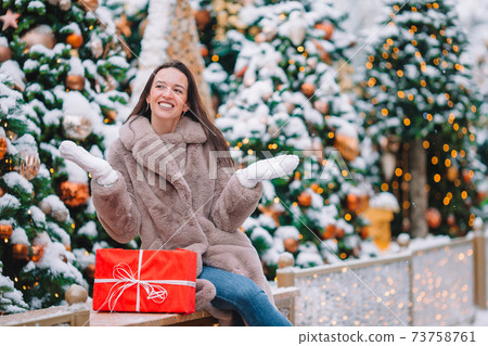 Happy girl near fir-tree branch in snow for new year. 73758761