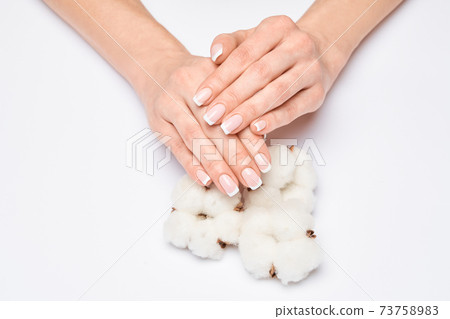 Beautiful Female Hands with French manicure over light grey background 73758983