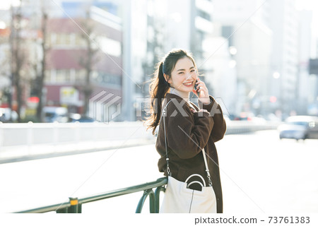 A young lady calling on a smartphone A young lady calling on a smartphone 73761383