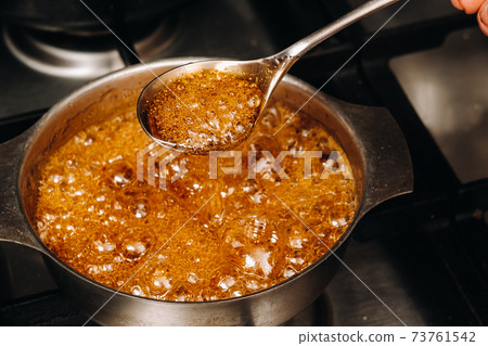 Preparation of sugar candies at home.A taste of our childhood.Rooster lollipops.Boiling Sugar caramel Preparation of sugar candies at home.A taste of our childhood.Rooster lollipops.Boiling Sugar caramel 73761542