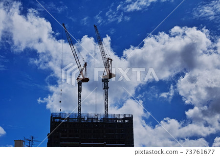 Crane silhouette in dynamic clouds 73761677