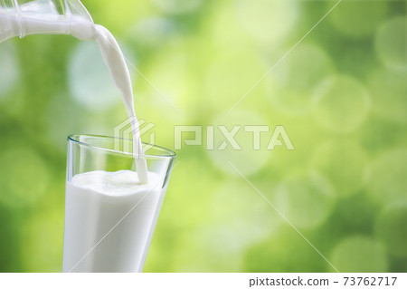 milk pouring into glass 73762717
