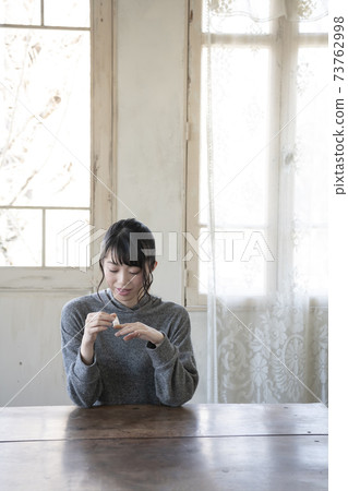 A woman who puts a bandage on her finger 73762998