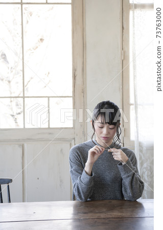 A woman who puts a bandage on her finger 73763000