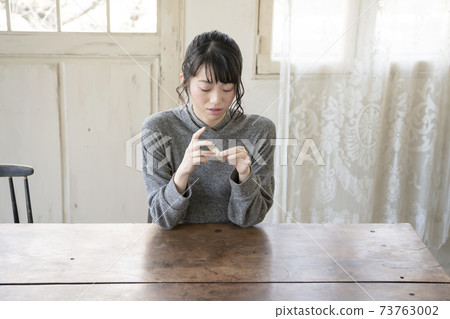 A woman who puts a bandage on her finger 73763002