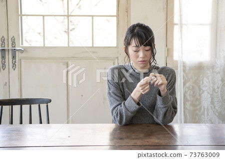 A woman who puts a bandage on her finger 73763009