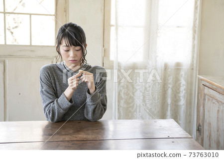 A woman who puts a bandage on her finger 73763010