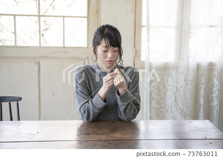 A woman who puts a bandage on her finger 73763011