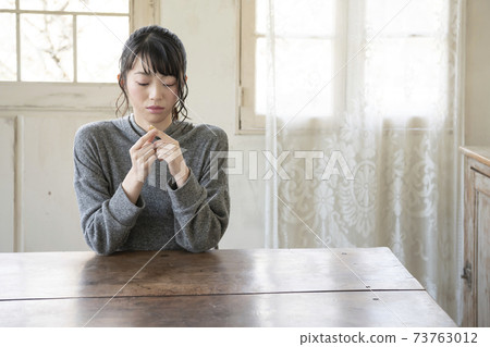 A woman who puts a bandage on her finger 73763012