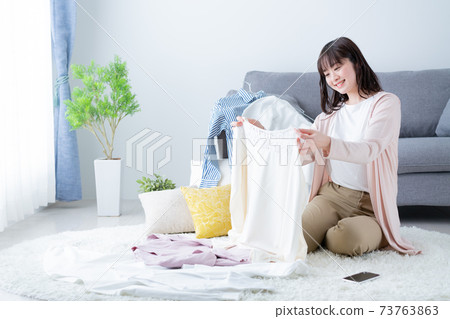 整理衣服和換衣服的年輕婦女 73763863