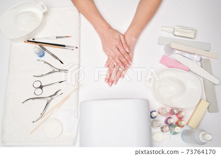 top view of manicure tools and Woman Preparing her hands for getting manicure procedure top view of manicure tools and Woman Preparing her hands for getting manicure procedure 73764170
