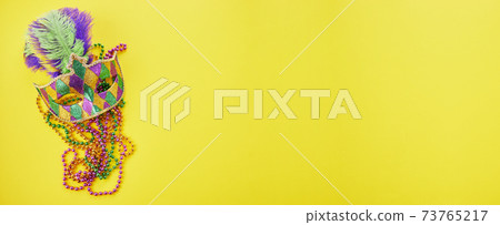 Mardi gras or carnival mask with beads on yellow background. Venetian mask. Mardi gras or carnival mask with beads on yellow background. Venetian mask. 73765217