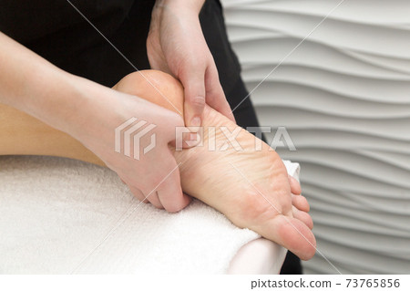 Massage the heels and feet of a person's leg. Close-up 73765856