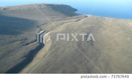 Abstract aerial view of steppe landscape with dusty roads in central Spain. Satellite, drone, airplane, hang gliding view image. 73767649