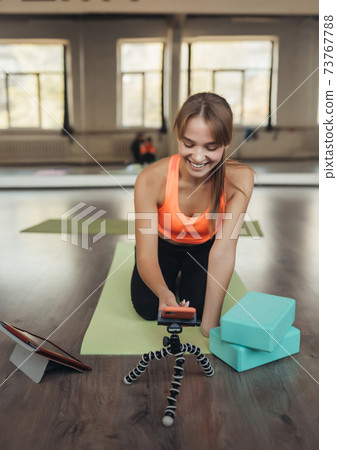 Young woman practicing yoga, is engaged with the teacher online. 73767788