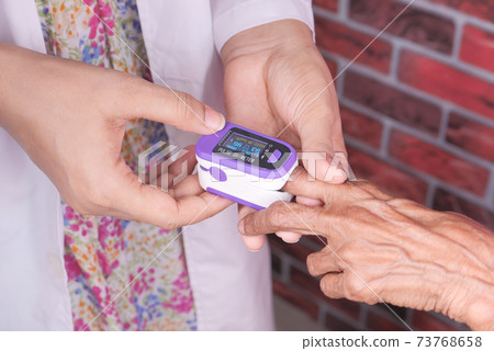 senior women hand using pulse oximeter 73768658