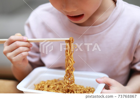 Toddler girl eating instant fried noodles Toddler girl eating instant fried noodles 73768867