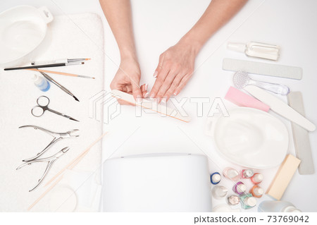 top view of manicure tools and Woman Preparing her hands for getting manicure procedure top view of manicure tools and Woman Preparing her hands for getting manicure procedure 73769042