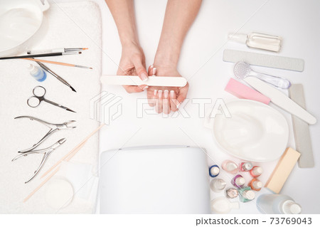 top view of manicure tools and Woman Preparing her hands for getting manicure procedure top view of manicure tools and Woman Preparing her hands for getting manicure procedure 73769043