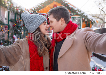 Joyful young couple bonding and taking selfie outdoors Joyful young couple bonding and taking selfie outdoors 73769839