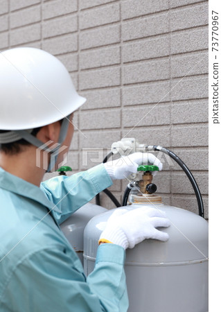 Workers inspecting propane gas cylinders Workers inspecting propane gas cylinders 73770967