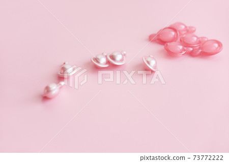 pink cosmetic capsules on pink background. serum or cream pink cosmetic capsules on pink background. serum or cream 73772222