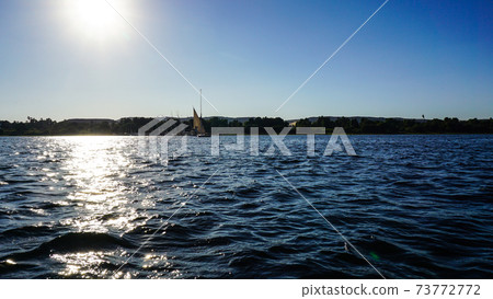 Sunny crusing in Egypt Nile river with fellucca boat yacht bright blue sky Sunny crusing in Egypt Nile river with fellucca boat yacht bright blue sky 73772772