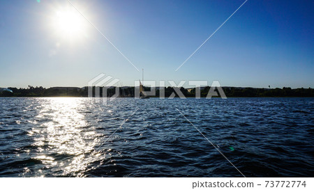 Sunny crusing in Egypt Nile river with fellucca boat yacht bright blue sky Sunny crusing in Egypt Nile river with fellucca boat yacht bright blue sky 73772774