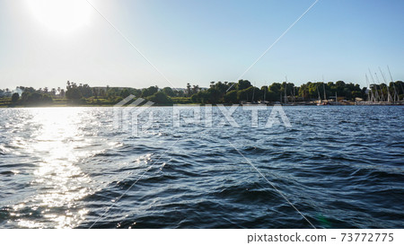 Sunny crusing in Egypt Nile river with fellucca boat yacht bright blue sky Sunny crusing in Egypt Nile river with fellucca boat yacht bright blue sky 73772775