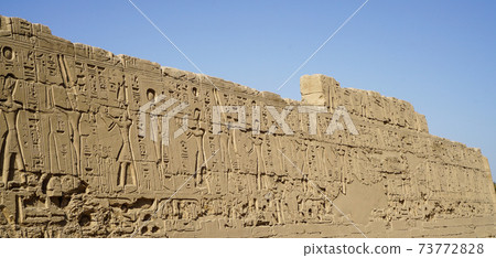 Karnak temple heiroglyphic pharaoh and god carving on stone wall 73772828