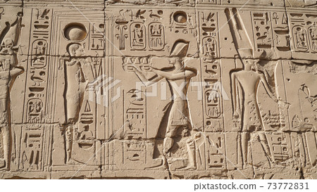 Karnak temple heiroglyphic pharaoh and god carving on stone wall 73772831