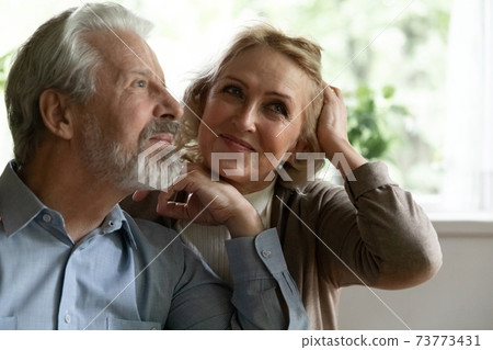 Close up dreamy mature spouses dreaming together, visualizing future Close up dreamy mature spouses dreaming together, visualizing future 73773431