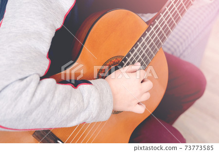 Learning to play the guitar. Music education. cropped boy playing acoustic guitar. Learning to play the guitar. Music education. cropped boy playing acoustic guitar. 73773585