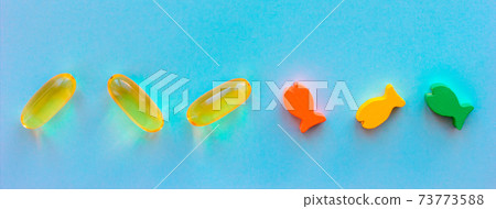 Fish collagen capsules and fishes on blue background. banner for your projects. Fish collagen capsules and fishes on blue background. banner for your projects. 73773588