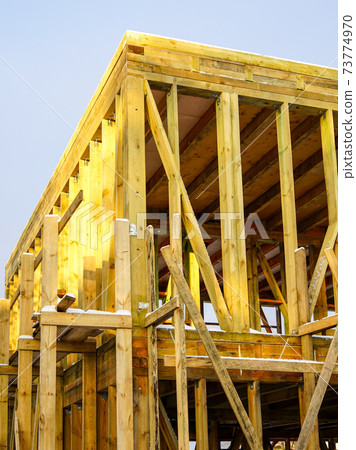 natural wooden construction on the construction site of a two-storey residential house natural wooden construction on the construction site of a two-storey residential house 73774970