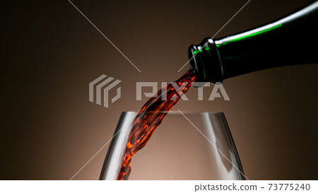 Pouring red wine into the glass 73775240